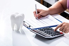 Patient calculating cost of cosmetic dentistry in McMinnville