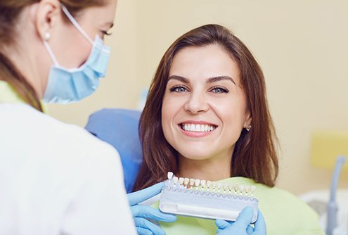 Dentist finding correct shade for patient’s dental crown