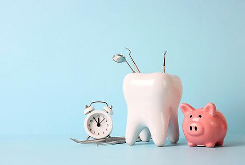A tooth model with medical instruments, a piggy bank, and an alarm clock on a blue background