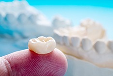 A closeup of a dental crown on a finger