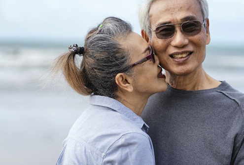 a couple walking on a beach and smiling