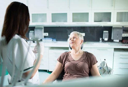 mature woman talking to dentist about dentures in McMinnville 