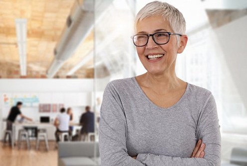 older woman smiling and crossing her arms 