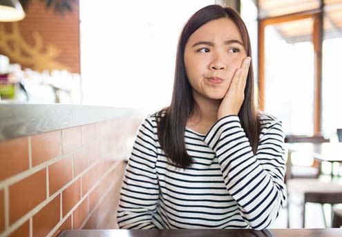 Woman in café with questions for her emergency dentist in McMinnville 