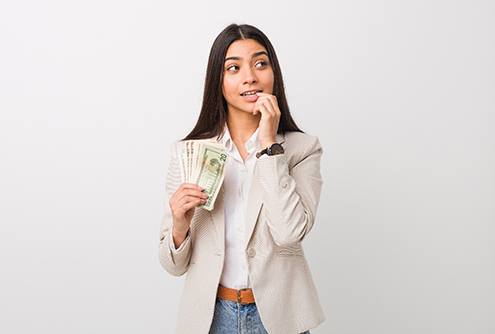 woman thinking of the cost of tooth extraction in McMinnville