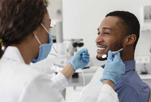 young man smiling while visiting his dentist 