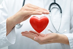 Doctor holding heart shape to illustrate cardiovascular health