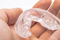 An up-close view of a person holding a clear mouthguard