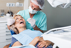 A woman having her teeth examined by her implant dentist