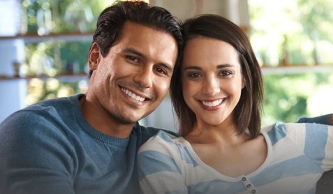 Smiling man and woman sitting on couch
