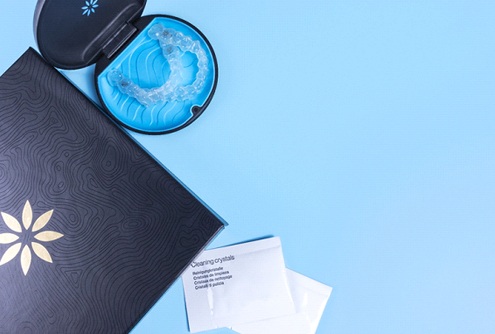 Invisalign aligners sitting in a protective case complete with additional information and cleaning crystal packets