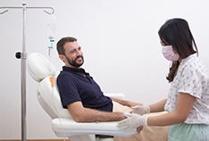 a patient receiving IV sedation from a dental assistant 