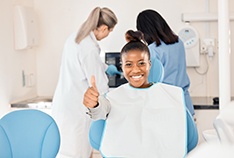 a dental patient smiling and giving a thumbs-up
