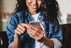 Woman smiling while looking at phone