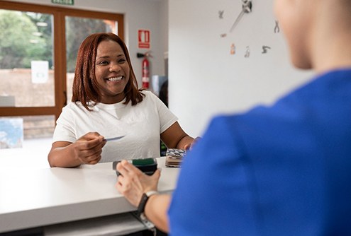 a woman paying at the dentist’s office