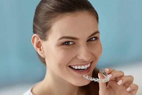 Woman placing Invisalign clear aligner