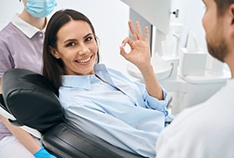 a patient giving the okay sign after dental treatment
