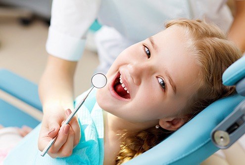 Smiling young gilr in dental chair