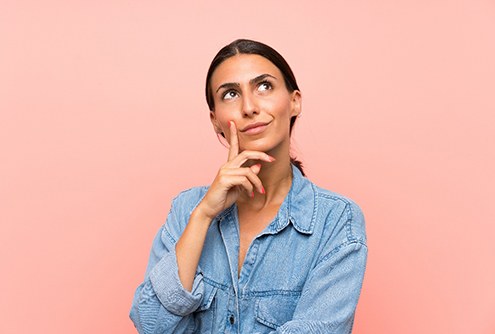 Woman thinking with pink background
