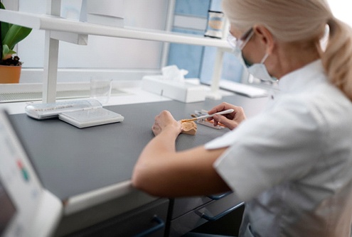 A dental lab technician creating veneers