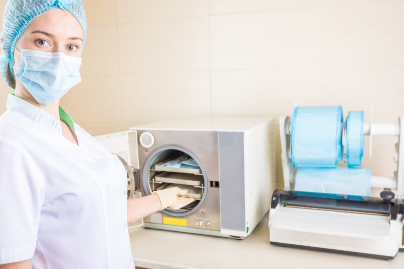 a dental staff member sanitizes the instruments in order for them to be reused