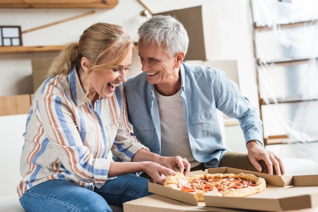 Older couple enjoying a pizza.