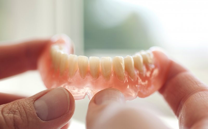 a person holding dentures in McMinnville