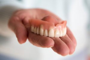 a person holding a denture