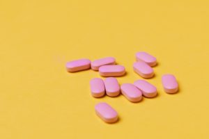 Pink pills on yellow background